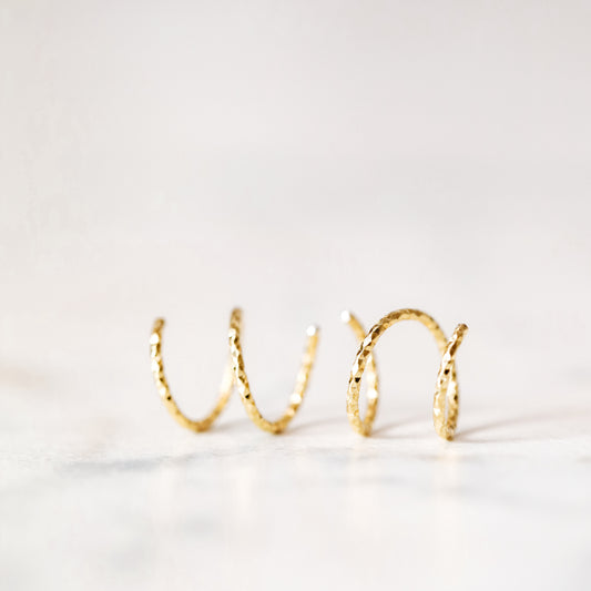 Minimal gold double hoop earrings with spiral twist design worn on ear, illusion of double piercing, diamond cut sterling silver jewelry