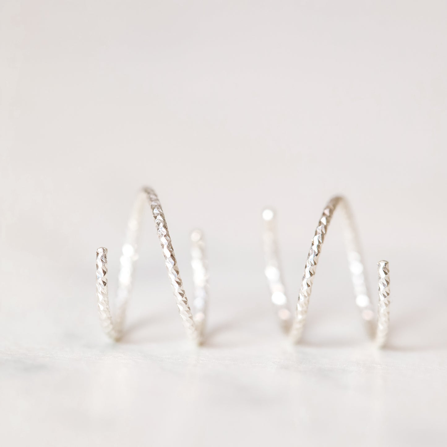 Minimal silver double hoop earrings on ear, tiny spiral earrings, sterling silver illusion double piercing jewelry