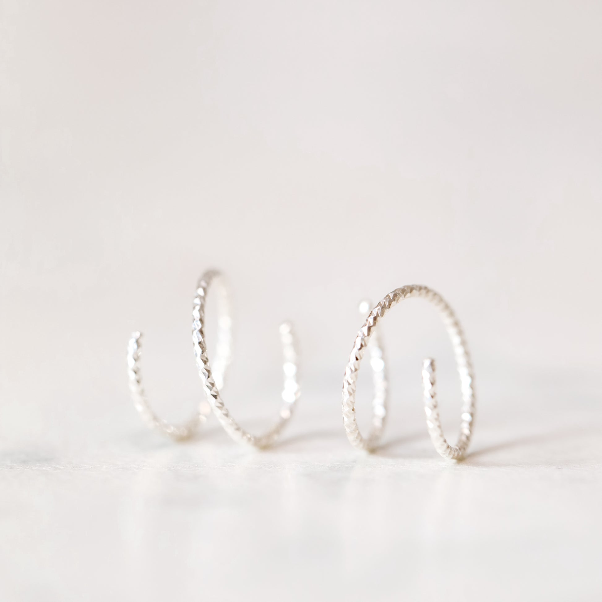 Minimal silver double hoop earrings on ear, tiny spiral earrings, sterling silver illusion double piercing jewelry