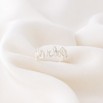 Handmade Sterling Silver wire ring with the name "Carlotta" in cursive on a soft white background.