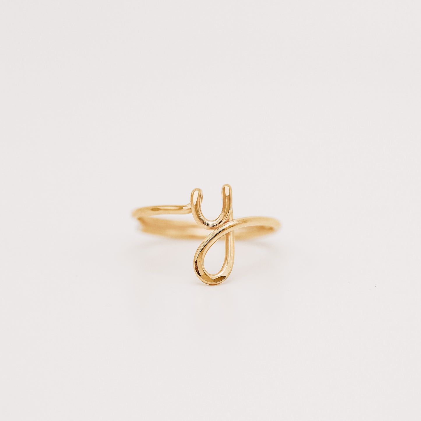 Dainty handmade gold wire ring featuring a lowercase cursive letter Y.