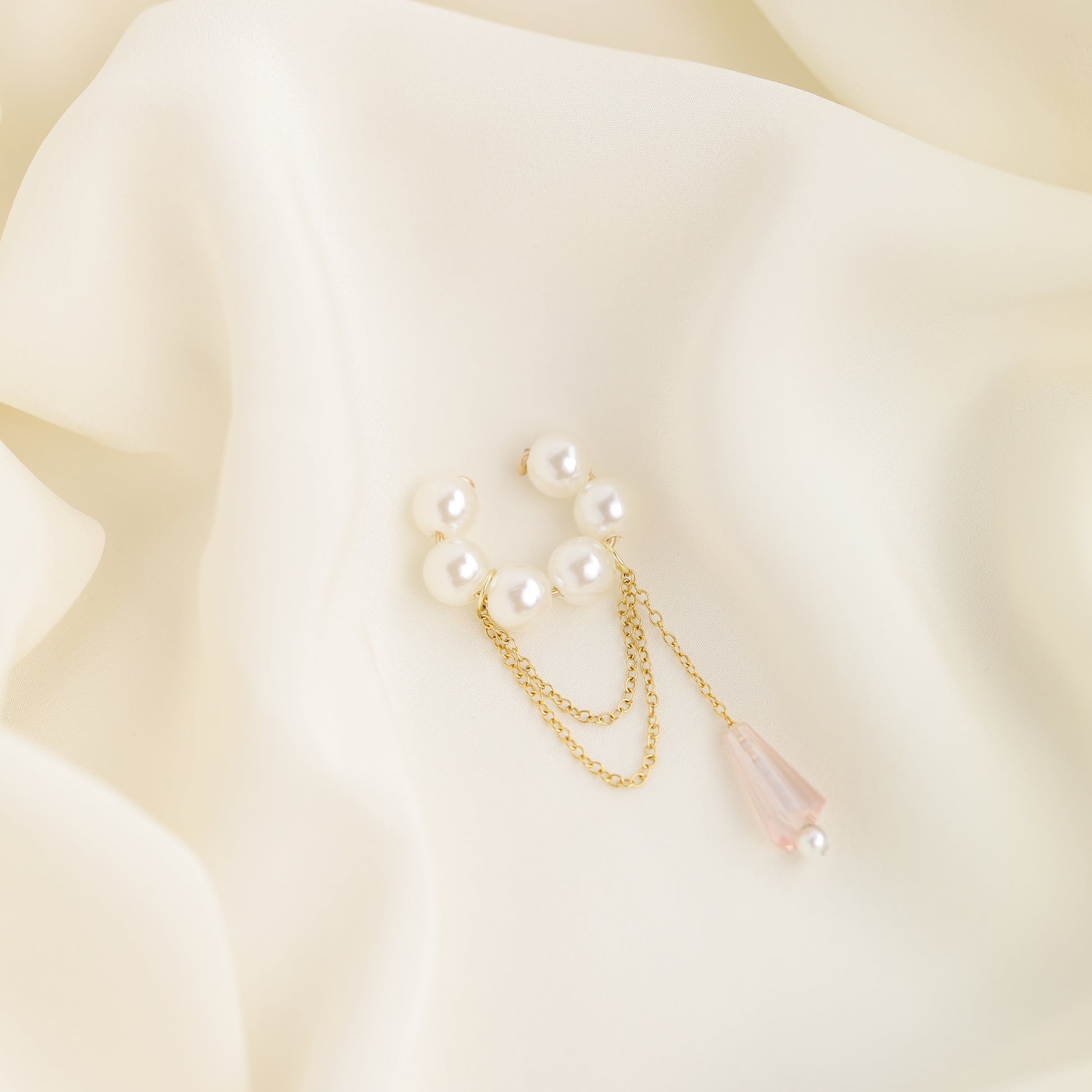 Dainty pearl crystal conch ear cuff shown as a no-piercing cartilage accessory, featuring artificial pearls around the conch area, delicate draped chains and a dangling faceted crystal drop, handmade and available in sterling silver 925, 14k gold filled or 14k rose gold filled.