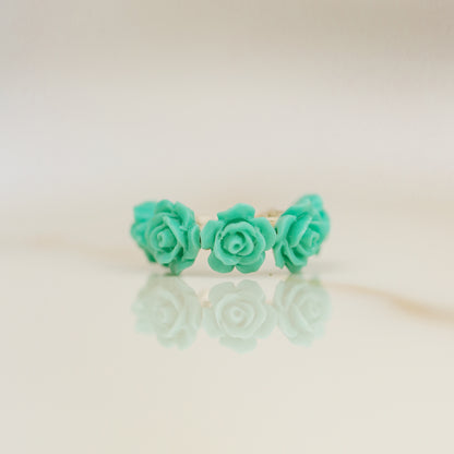 Turquoise aqua blue resin rose conch ear cuff worn on the ear as a colorful floral cartilage cuff