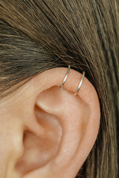 Handmade set of gold criss cross and double line helix ear cuffs for non-pierced ears, adjustable minimalist jewelry available in 12k gold filled, sterling silver, and 16 gauge black aluminum.