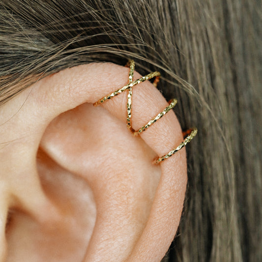 No-piercing double line and criss cross helix ear cuff worn on the upper ear, available in smooth and diamond cut finish options for cartilage styling.