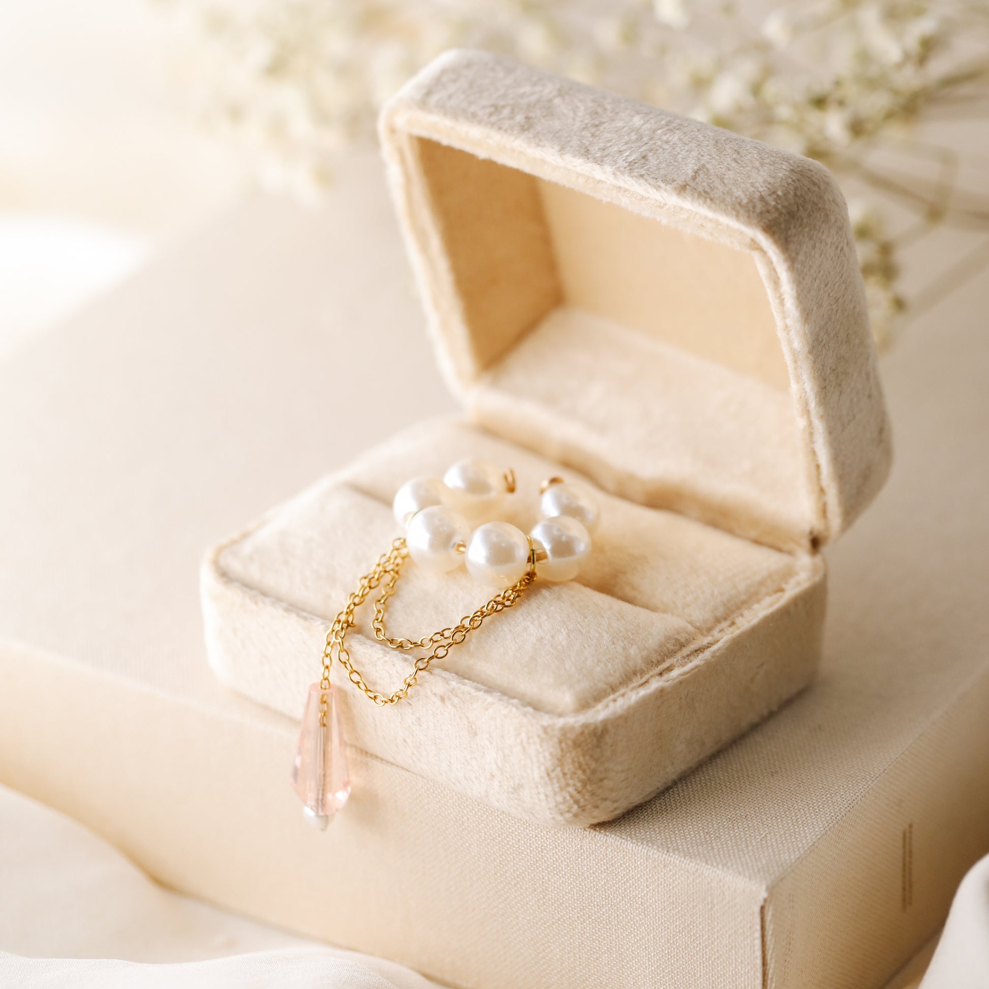 Dainty pearl crystal conch ear cuff shown as a no-piercing cartilage accessory, featuring artificial pearls around the conch area, delicate draped chains and a dangling faceted crystal drop, handmade and available in sterling silver 925, 14k gold filled or 14k rose gold filled.