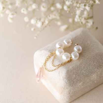 Dainty pearl crystal conch ear cuff shown as a no-piercing cartilage accessory, featuring artificial pearls around the conch area, delicate draped chains and a dangling faceted crystal drop, handmade and available in sterling silver 925, 14k gold filled or 14k rose gold filled.