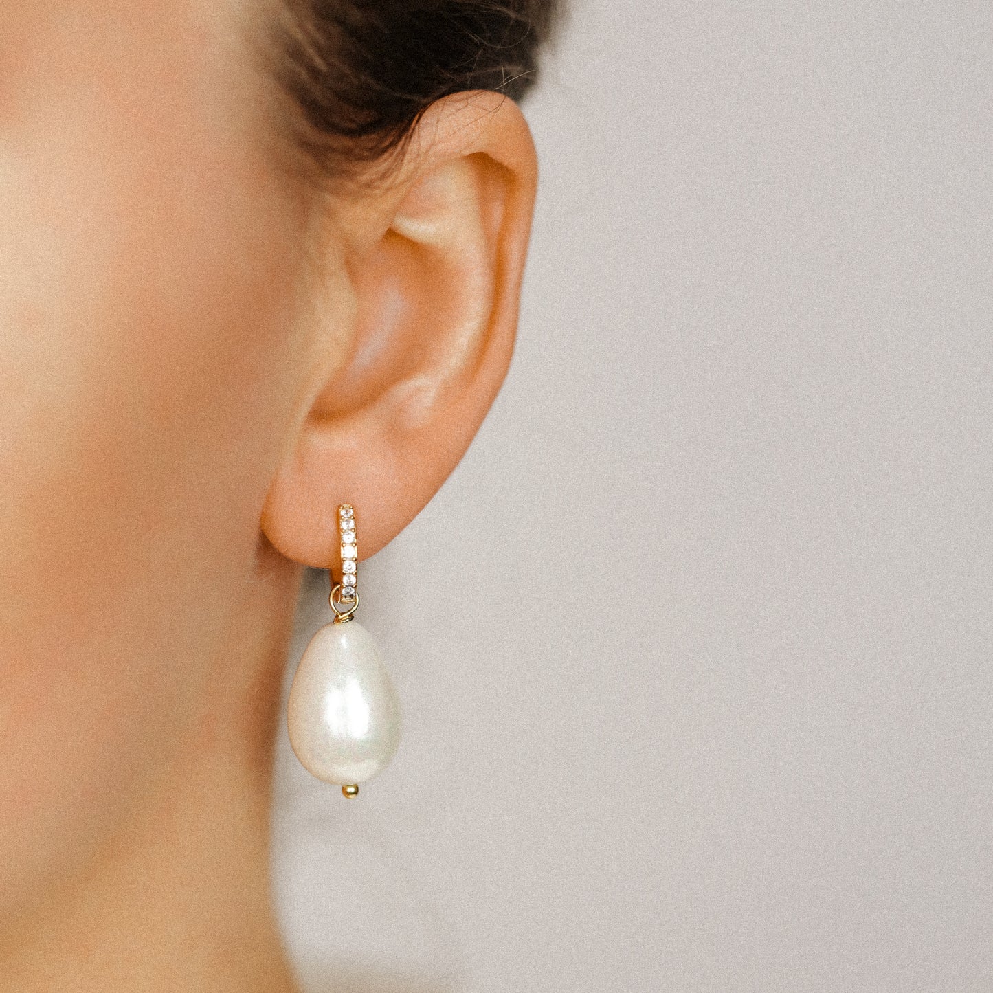 Side profile of a model wearing a luxurious 18k gold teardrop pearl drop earring, showcasing the elegant 35mm hanging length and bridal style.