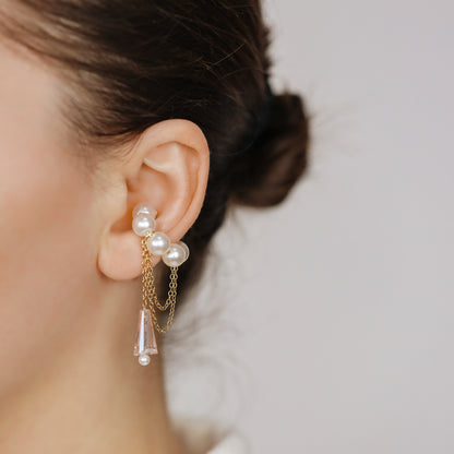 Dainty pearl crystal conch ear cuff shown as a no-piercing cartilage accessory, featuring artificial pearls around the conch area, delicate draped chains and a dangling faceted crystal drop, handmade and available in sterling silver 925, 14k gold filled or 14k rose gold filled.