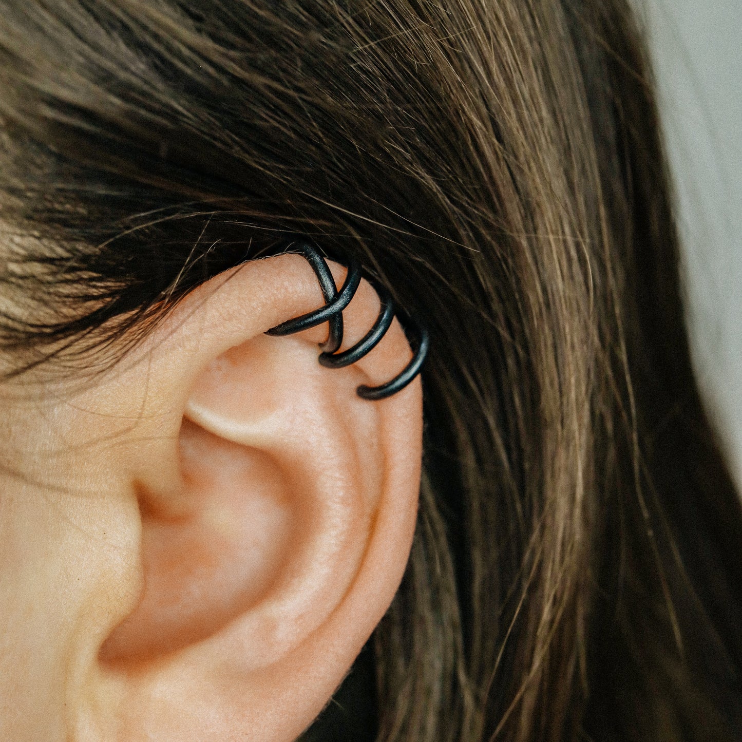 No-piercing double line and criss cross helix ear cuff shown on the upper ear, with smooth and diamond cut finish options for cartilage styling.