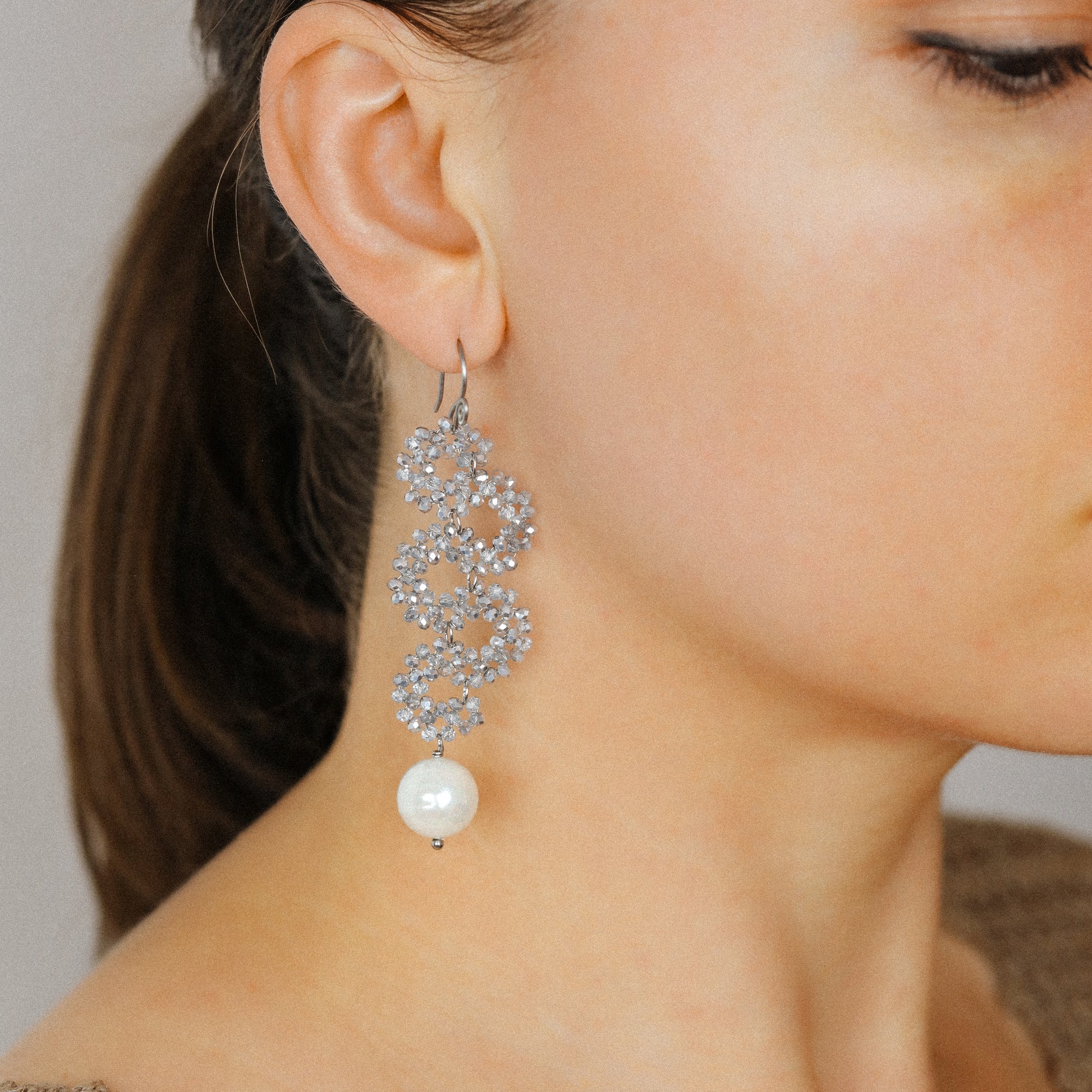 Elegant silver iridescent serpentine earrings worn with long cascading dangle design