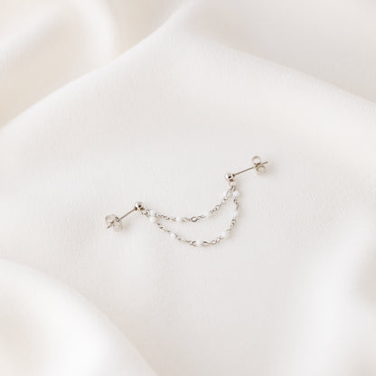 Silver double chain stud earring displayed on white fabric with push back closure