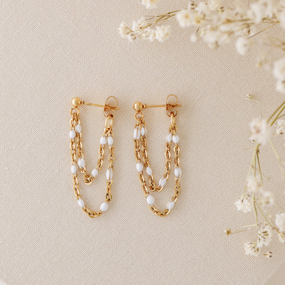 Gold chain stud earrings with layered drop design and delicate white bead accents