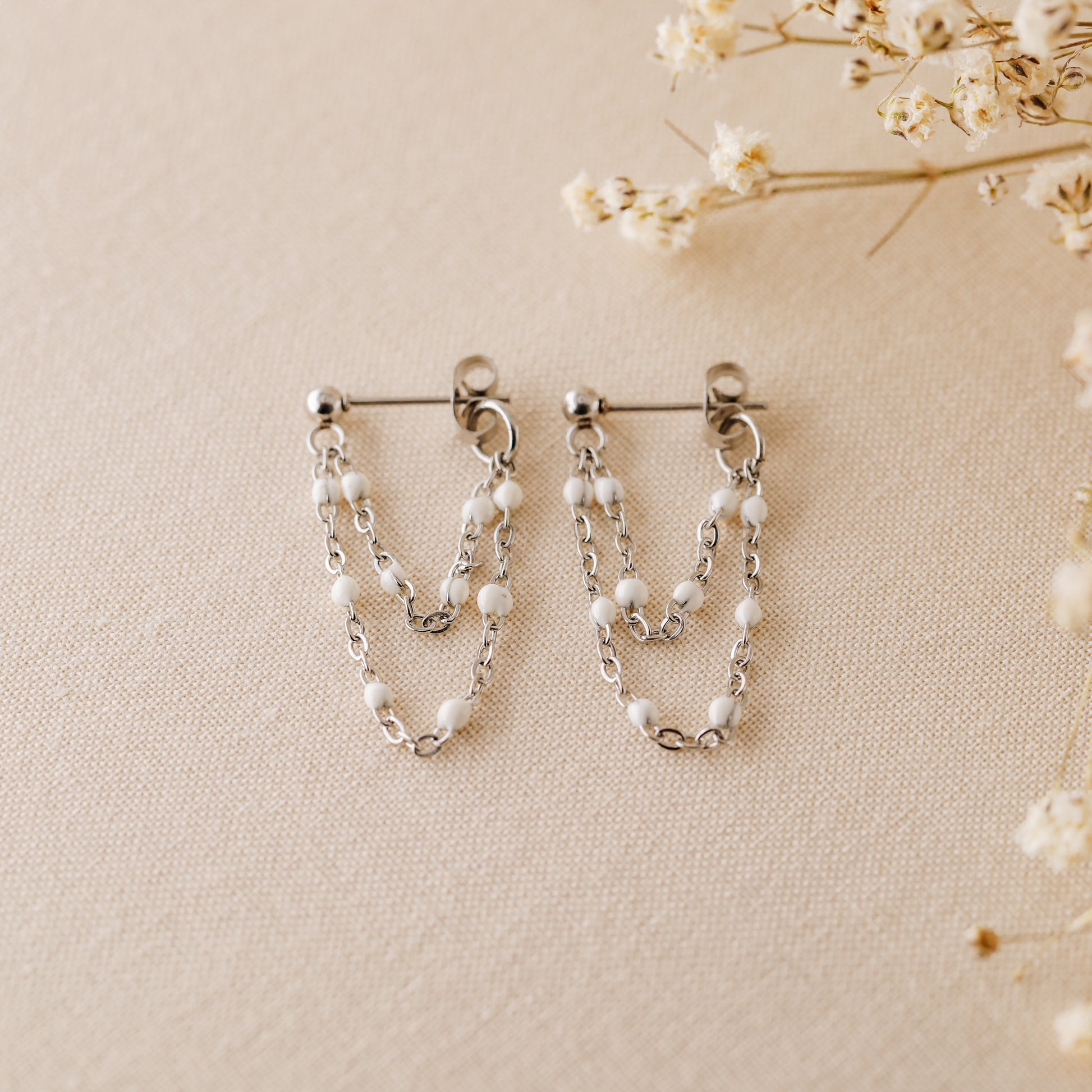 Silver chain dangle earrings with tiny white enamel beads and stud post closure