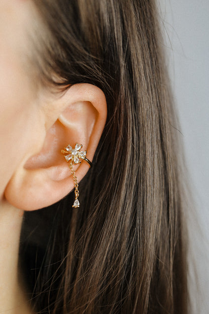 Sparkling flower ear cuff with dainty drop chain in 18k gold plated sterling silver and 925 silver, worn on cartilage without piercing.