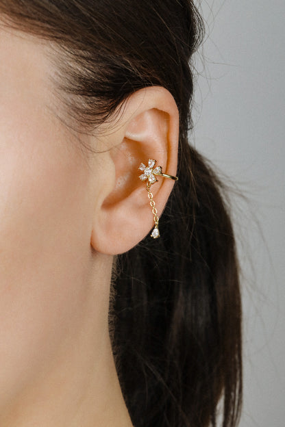 Sparkling flower ear cuff with dainty drop chain in 18k gold plated sterling silver and 925 silver, worn on cartilage without piercing.