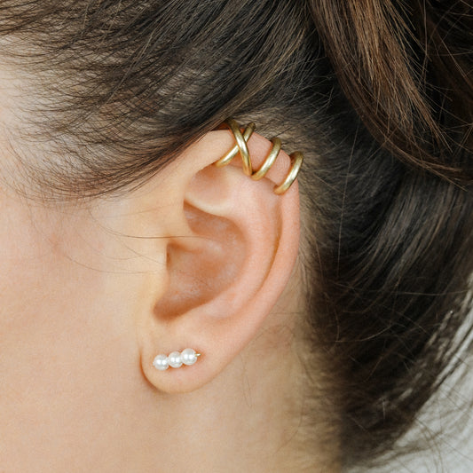 Adjustable no-piercing helix ear cuff shown worn on the upper cartilage area, available in silver, black and soft gold with Double Line and Criss-Cross style options for a bold stacked ear look.