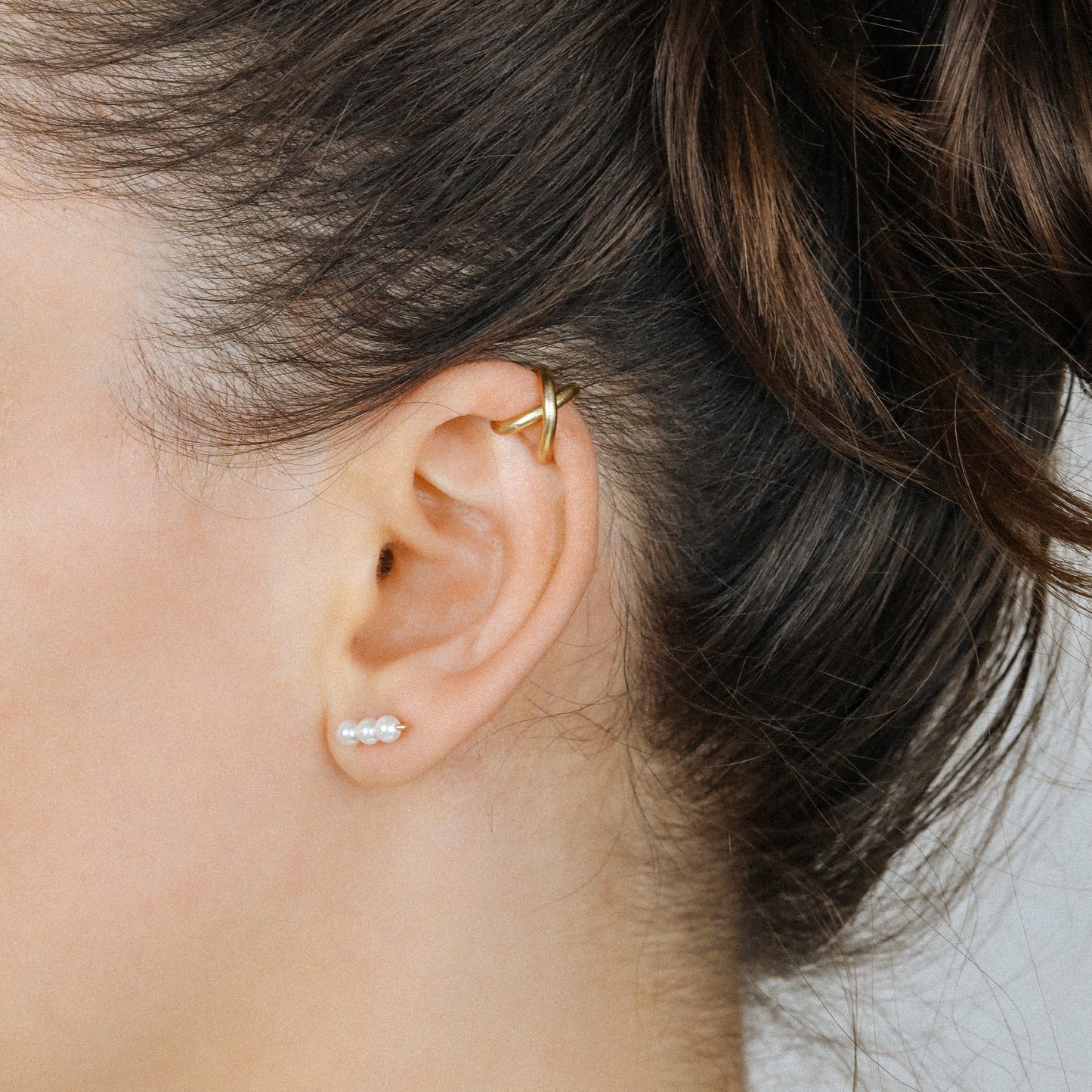 Adjustable no-piercing helix ear cuff shown worn on the upper cartilage area, available in silver, black and soft gold with Double Line and Criss-Cross style options for a bold stacked ear look.