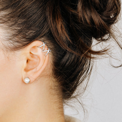 Adjustable no-piercing helix ear cuff shown worn on the upper cartilage area, available in silver, black and soft gold with Double Line and Criss-Cross style options for a bold stacked ear look.