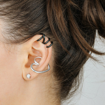 Adjustable no-piercing helix ear cuff shown worn on the upper cartilage area, available in silver, black and soft gold with Double Line and Criss-Cross style options for a bold stacked ear look.