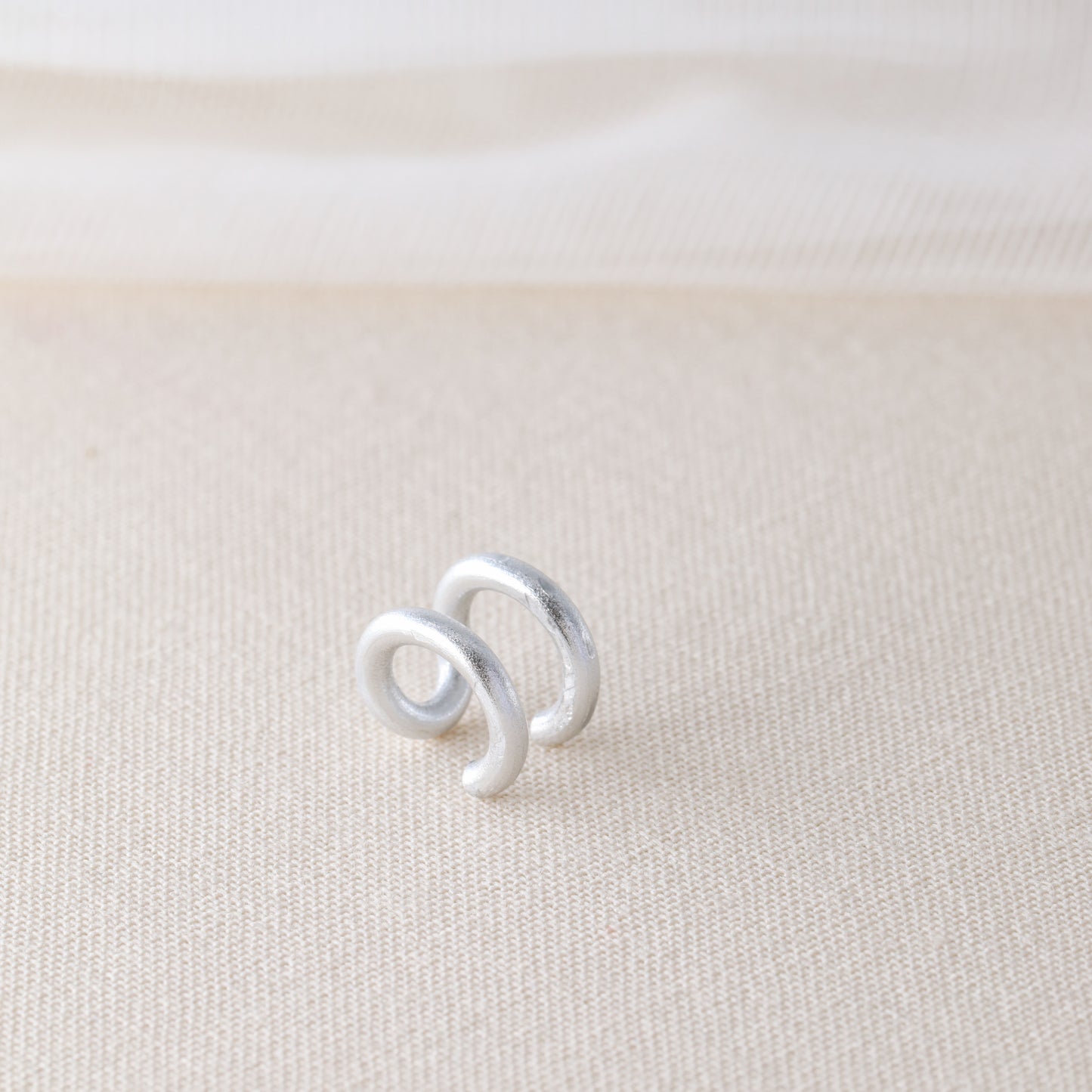 Adjustable no-piercing helix ear cuff shown worn on the upper cartilage area, available in silver, black and soft gold with Double Line and Criss-Cross style options for a bold stacked ear look.