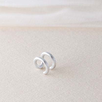 Adjustable no-piercing helix ear cuff shown worn on the upper cartilage area, available in silver, black and soft gold with Double Line and Criss-Cross style options for a bold stacked ear look.