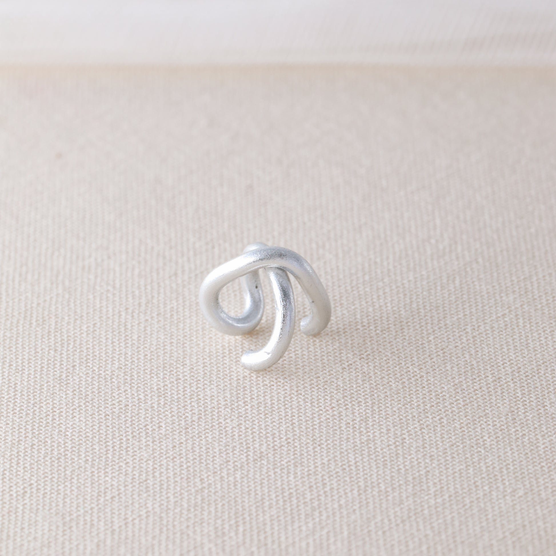 Adjustable no-piercing helix ear cuff shown worn on the upper cartilage area, available in silver, black and soft gold with Double Line and Criss-Cross style options for a bold stacked ear look.
