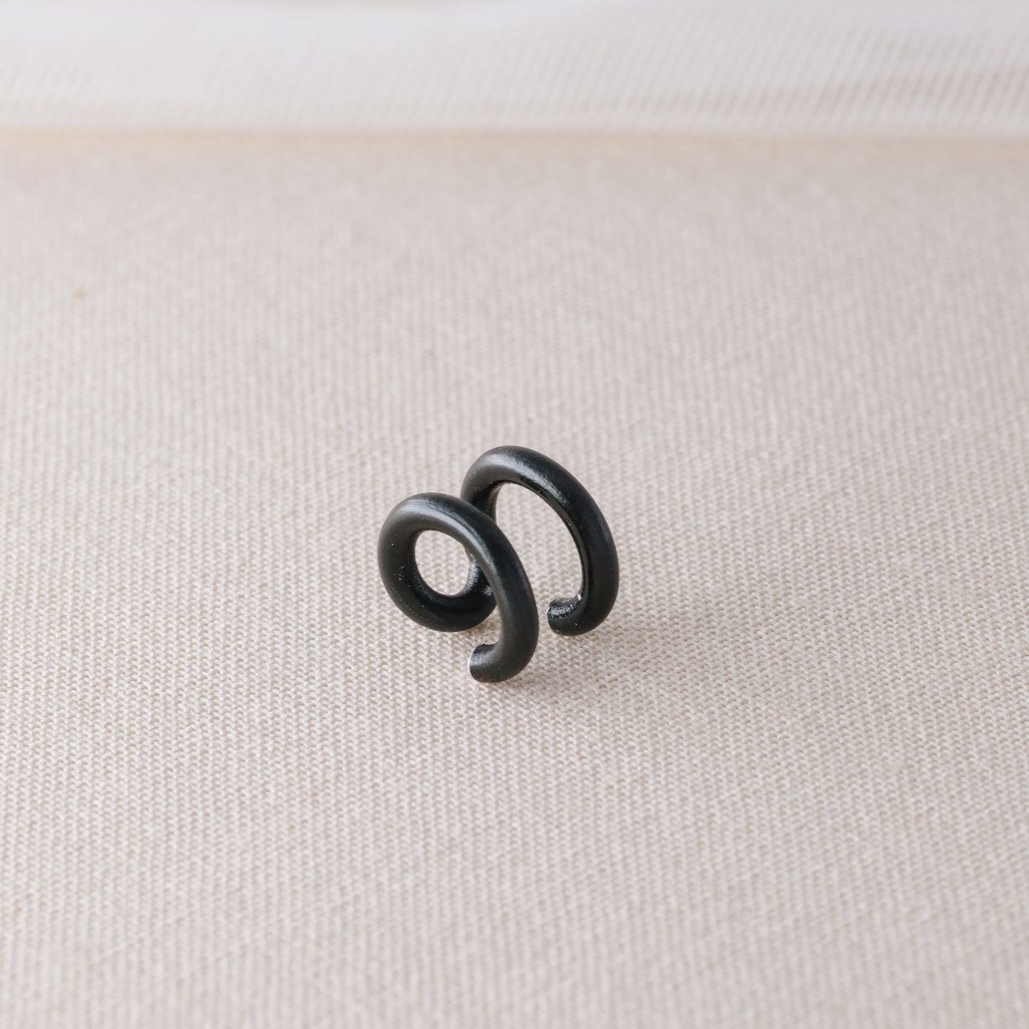 Adjustable no-piercing helix ear cuff shown worn on the upper cartilage area, available in silver, black and soft gold with Double Line and Criss-Cross style options for a bold stacked ear look.