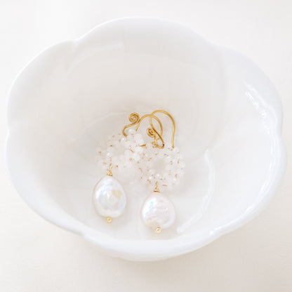 Stainless steel baroque pearl and white crystal wreath drop earrings presented inside a minimalist white ceramic flower-shaped bowl.