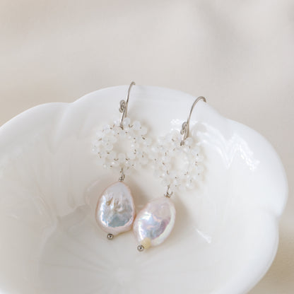 Stainless steel baroque pearl and white crystal wreath drop earrings presented inside a minimalist white ceramic flower-shaped bowl.