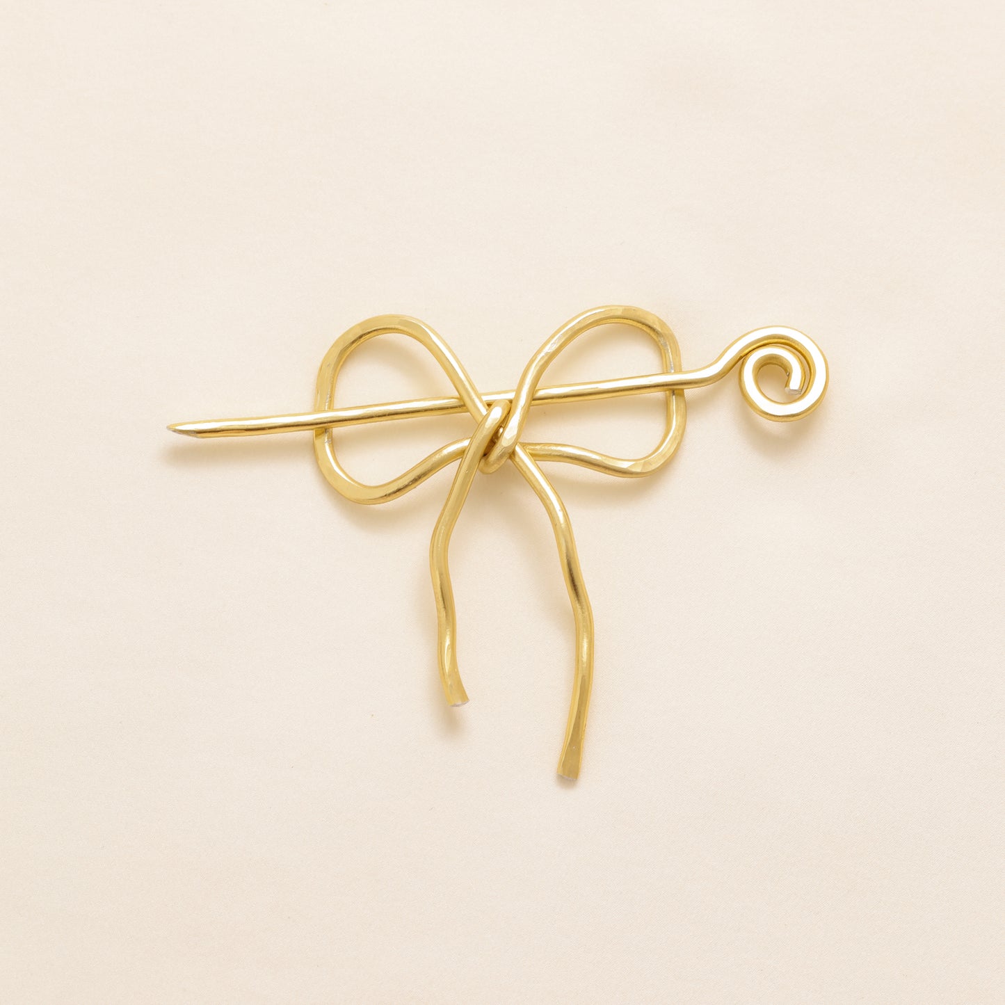 Handmade aluminum bow shawl pin brooch with matching removable stick pin, shown in gold and available in silver or gold finish, designed as a decorative and functional scarf fastener for shawls, sweaters, cardigans, knit wraps and crochet pieces, with a romantic bow shape and minimalist metal design.