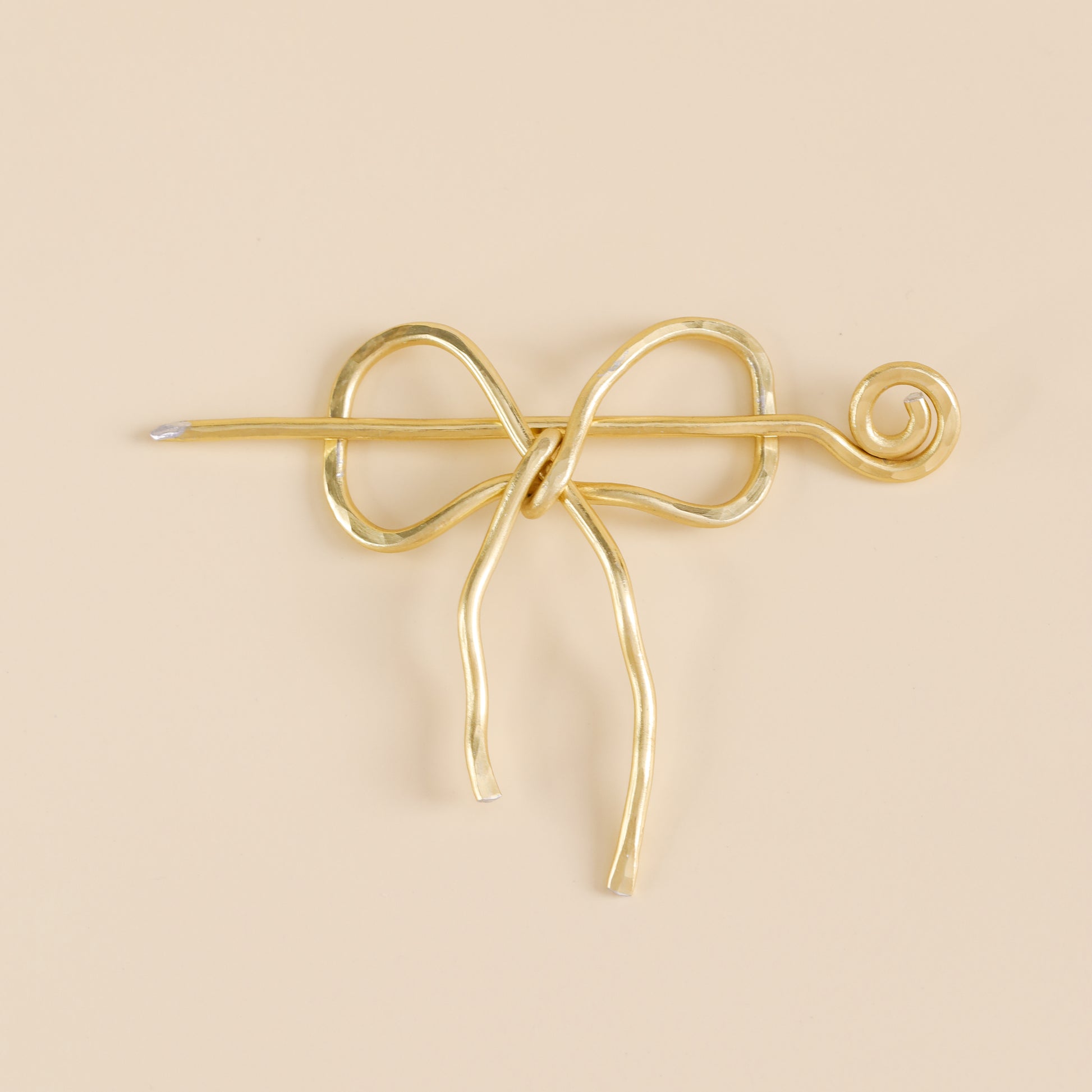 Handmade aluminum bow shawl pin brooch with matching removable stick pin, shown in gold and available in silver or gold finish, designed as a decorative and functional scarf fastener for shawls, sweaters, cardigans, knit wraps and crochet pieces, with a romantic bow shape and minimalist metal design.