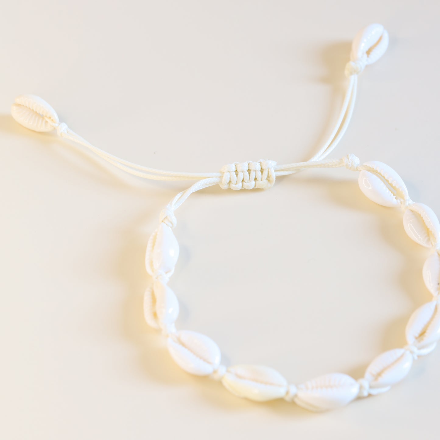 Adjustable cowrie shell anklet with sliding knot closure and natural white shells