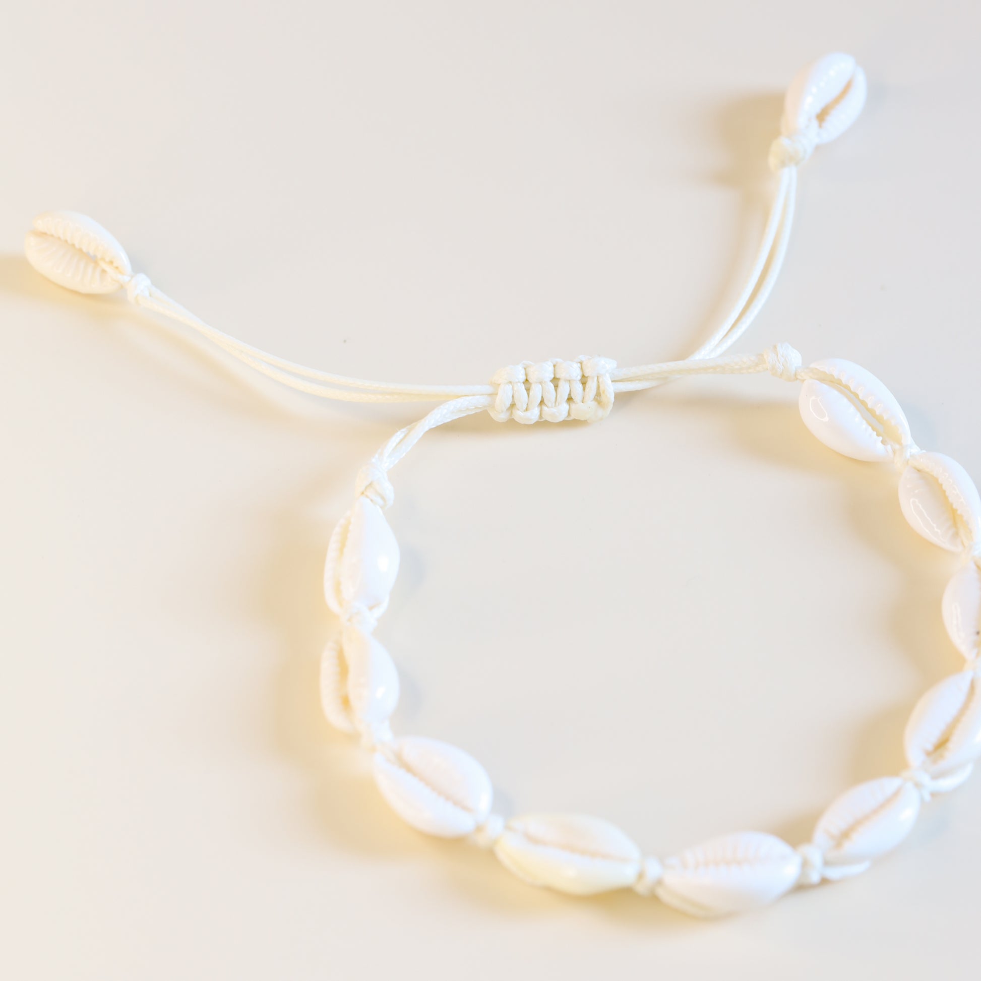 Adjustable cowrie shell anklet with sliding knot closure and natural white shells