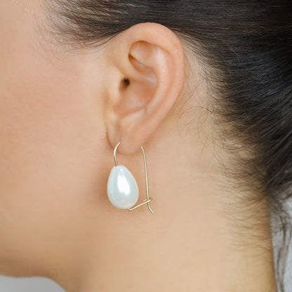 Handmade ceramic pearl teardrop earrings featuring large white pear-shaped pearls approximately 20 mm x 15 mm suspended from a minimalist curved wire hook, approximately 30 mm total length, available in solid 925 sterling silver, 14k gold filled or 14k rose gold filled.