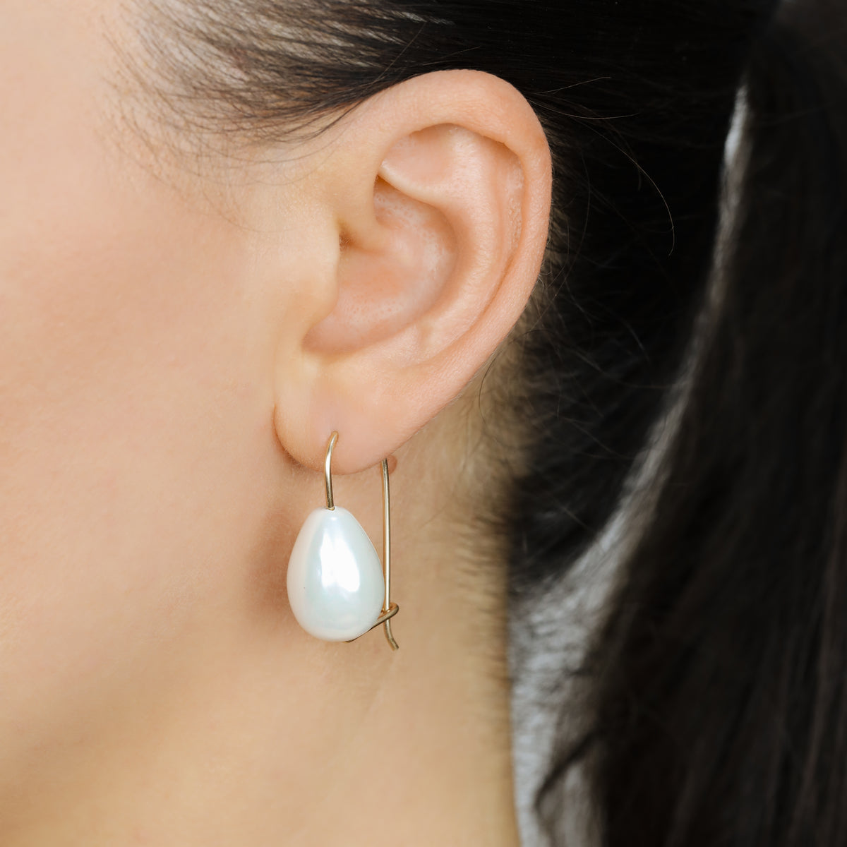 Handmade ceramic pearl teardrop earrings featuring large white pear-shaped pearls approximately 20 mm x 15 mm suspended from a minimalist curved wire hook, approximately 30 mm total length, available in solid 925 sterling silver, 14k gold filled or 14k rose gold filled.