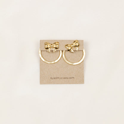 Pair of gold hammered round ear jackets displayed with decorative bow studs for a playful interchangeable earring combination.