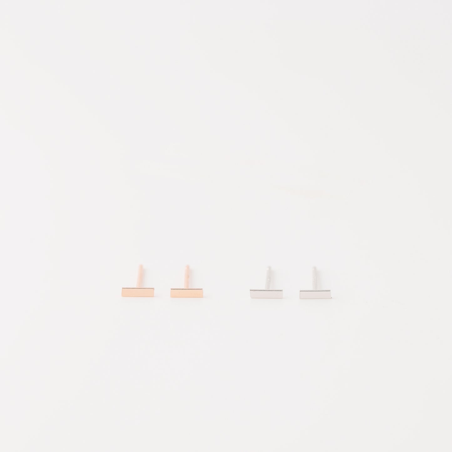 Tiny rectangle bar stud earrings in solid 925 sterling silver on white background