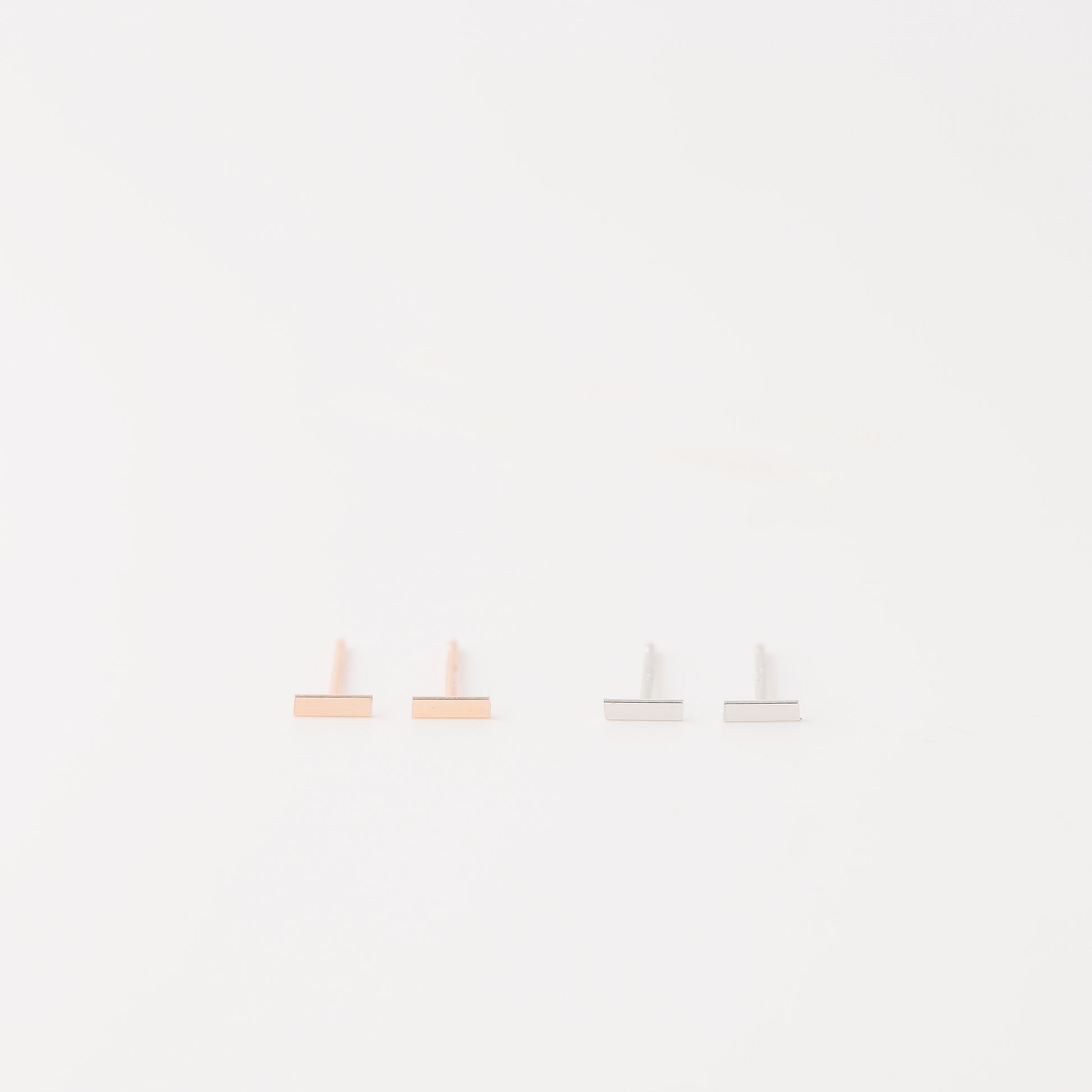 Tiny rectangle bar stud earrings in solid 925 sterling silver on white background
