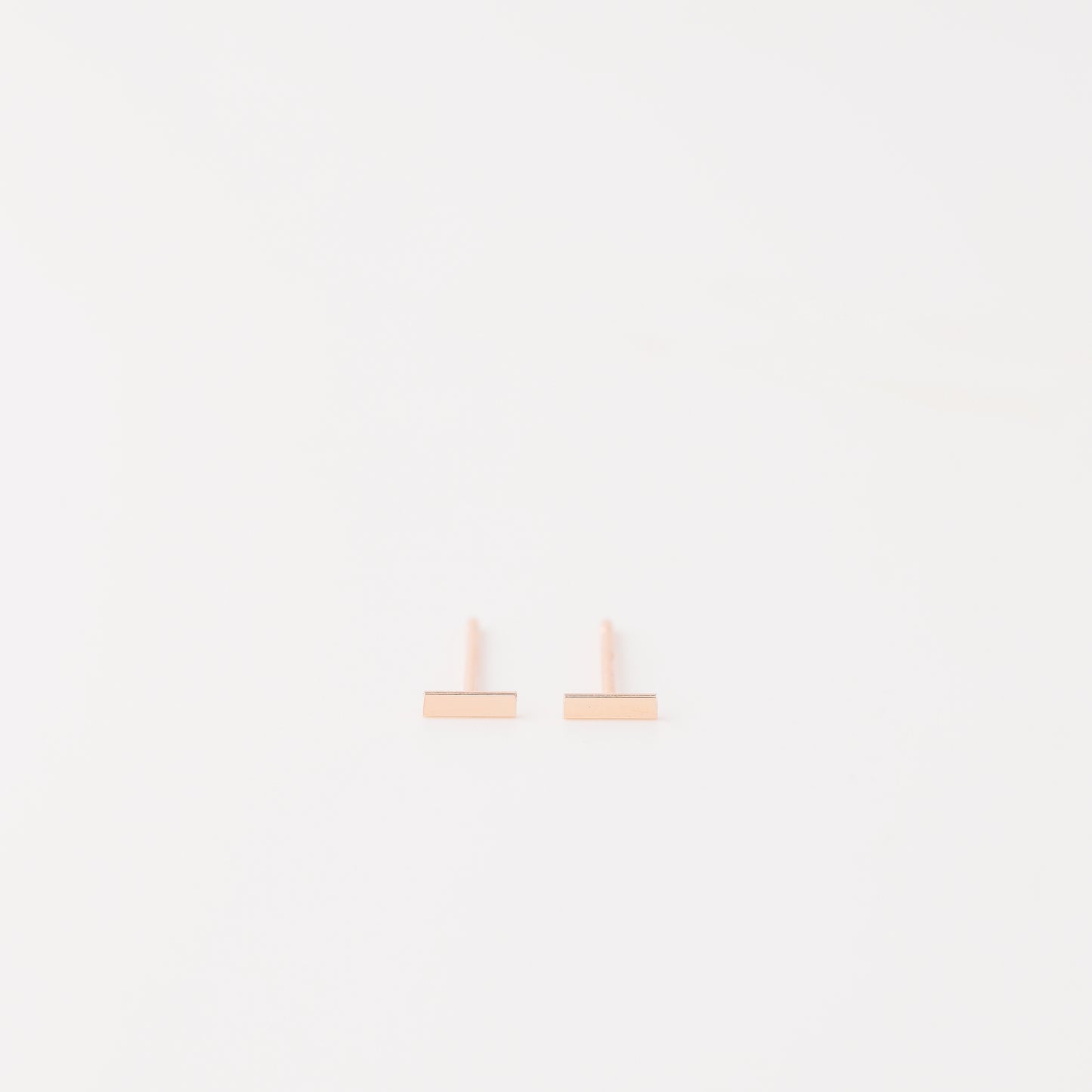 Tiny rectangle bar stud earrings in solid 925 sterling silver on white background