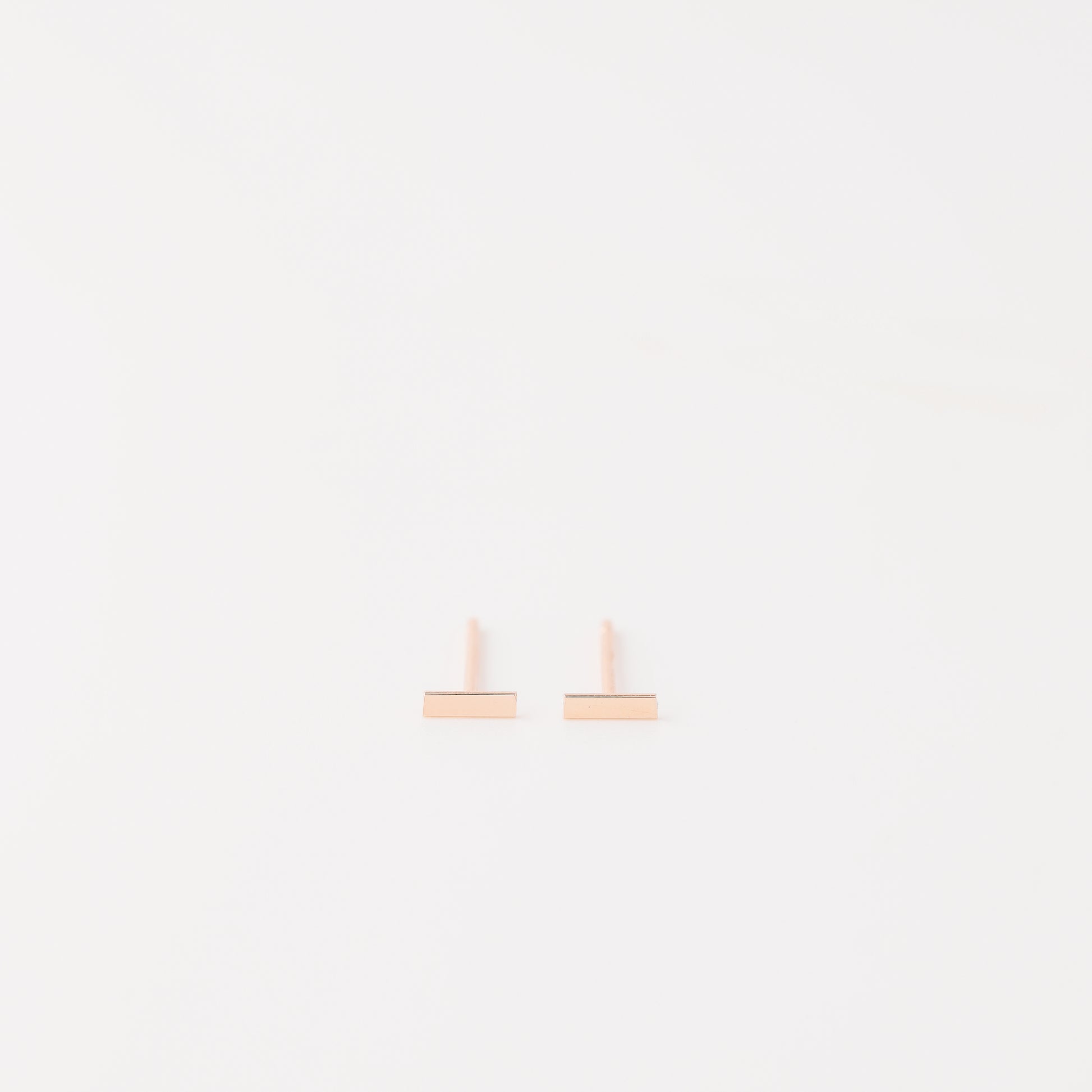 Tiny rectangle bar stud earrings in solid 925 sterling silver on white background