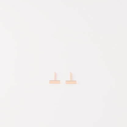 Tiny rectangle bar stud earrings in solid 925 sterling silver on white background