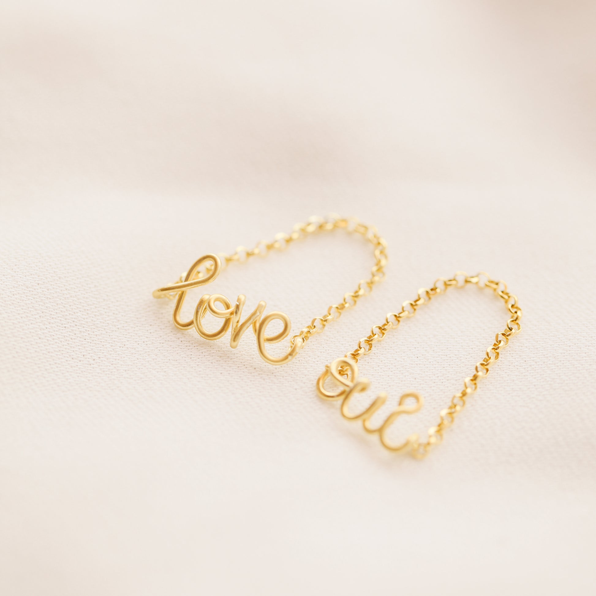 Gold personalized chain ring on neutral background