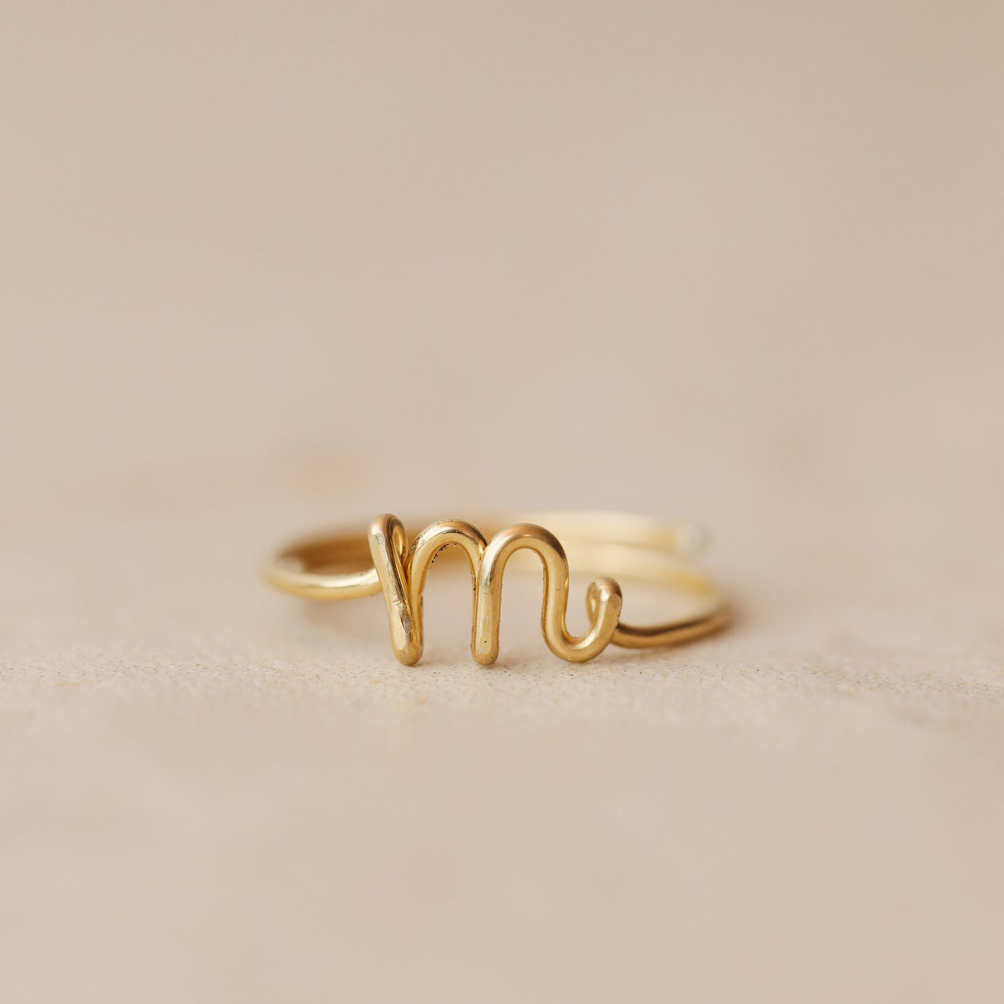 Handmade 14k gold filled wire ring shaped into the letter M.