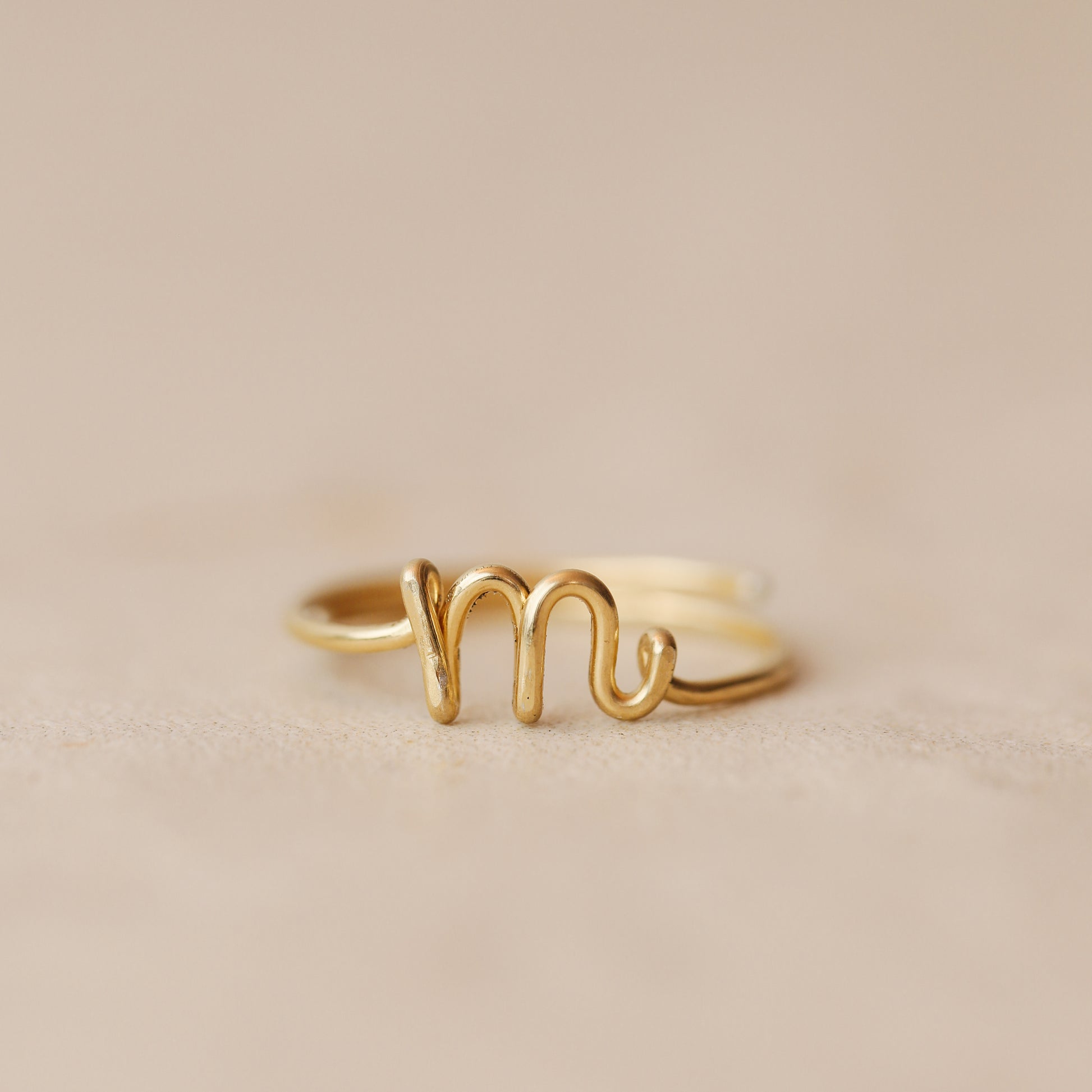 Handmade 14k gold filled wire ring shaped into the letter M.