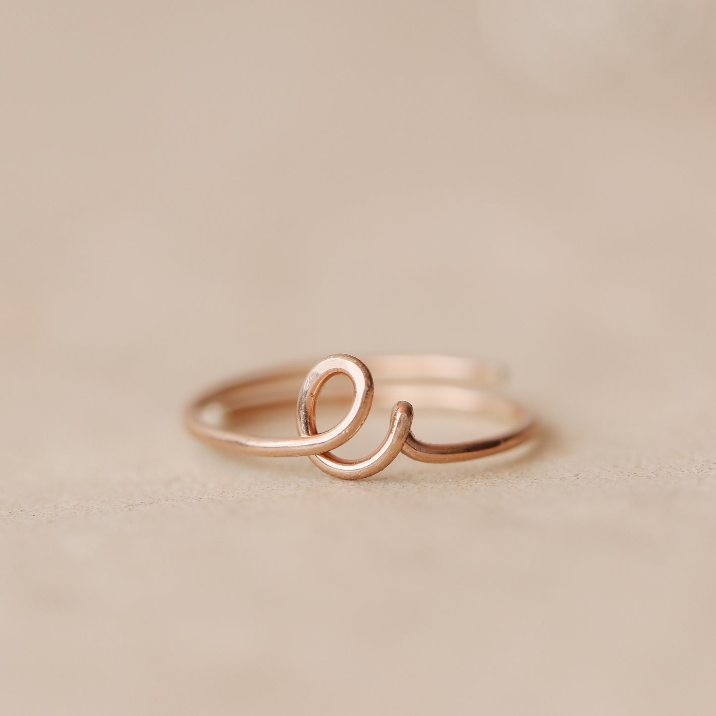 Handmade 14k rose gold filled wire ring shaped into the letter E.