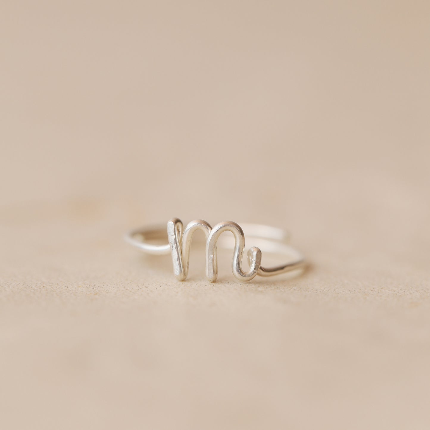 Handmade 925 sterling silver wire ring shaped into the letter M.