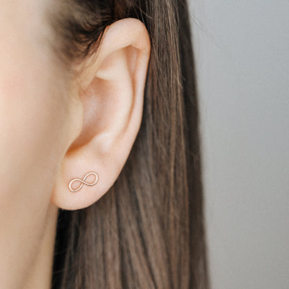 Rose gold infinity earrings on ear delicate minimalist jewelry