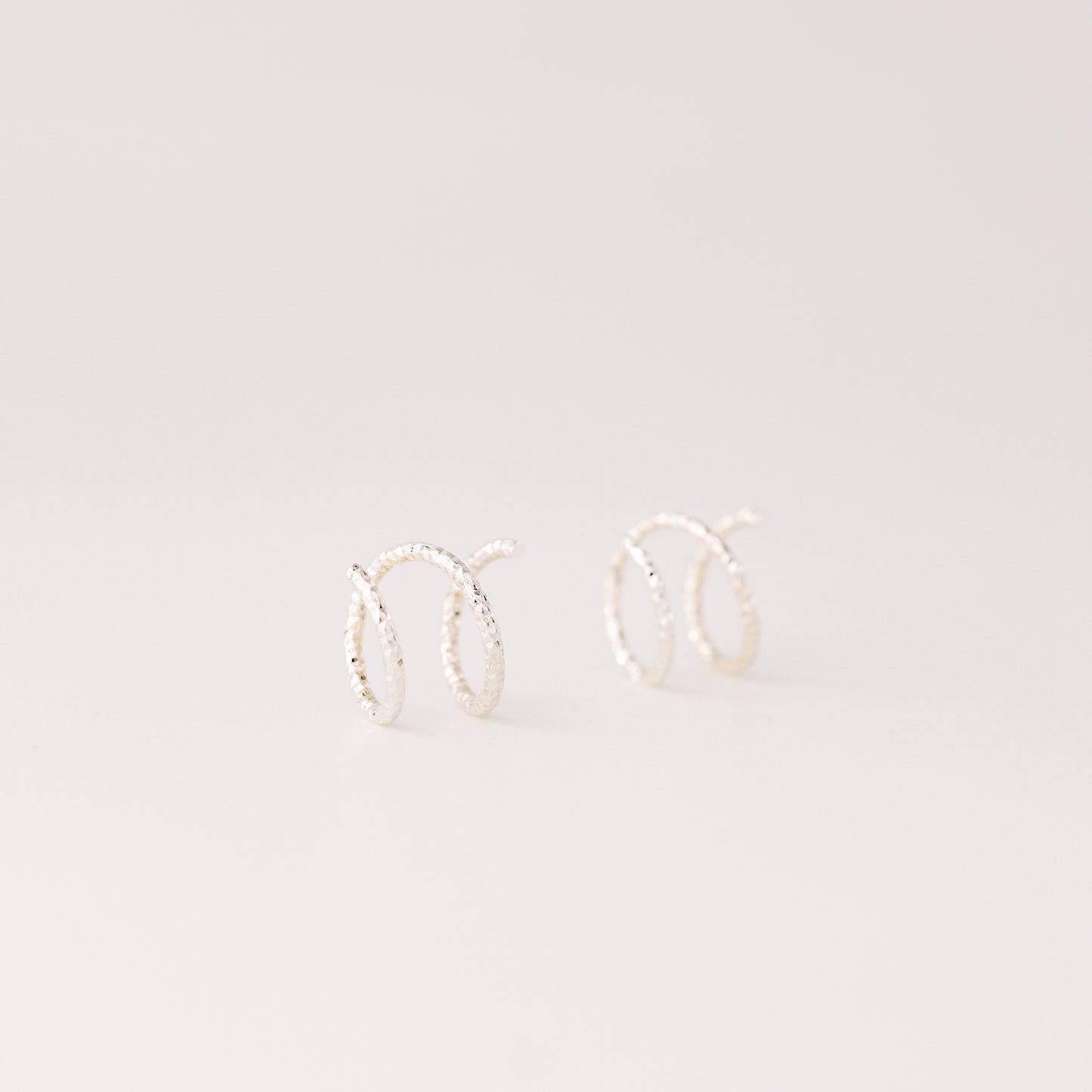 Minimal silver double hoop earrings on ear, tiny spiral earrings, sterling silver illusion double piercing jewelry