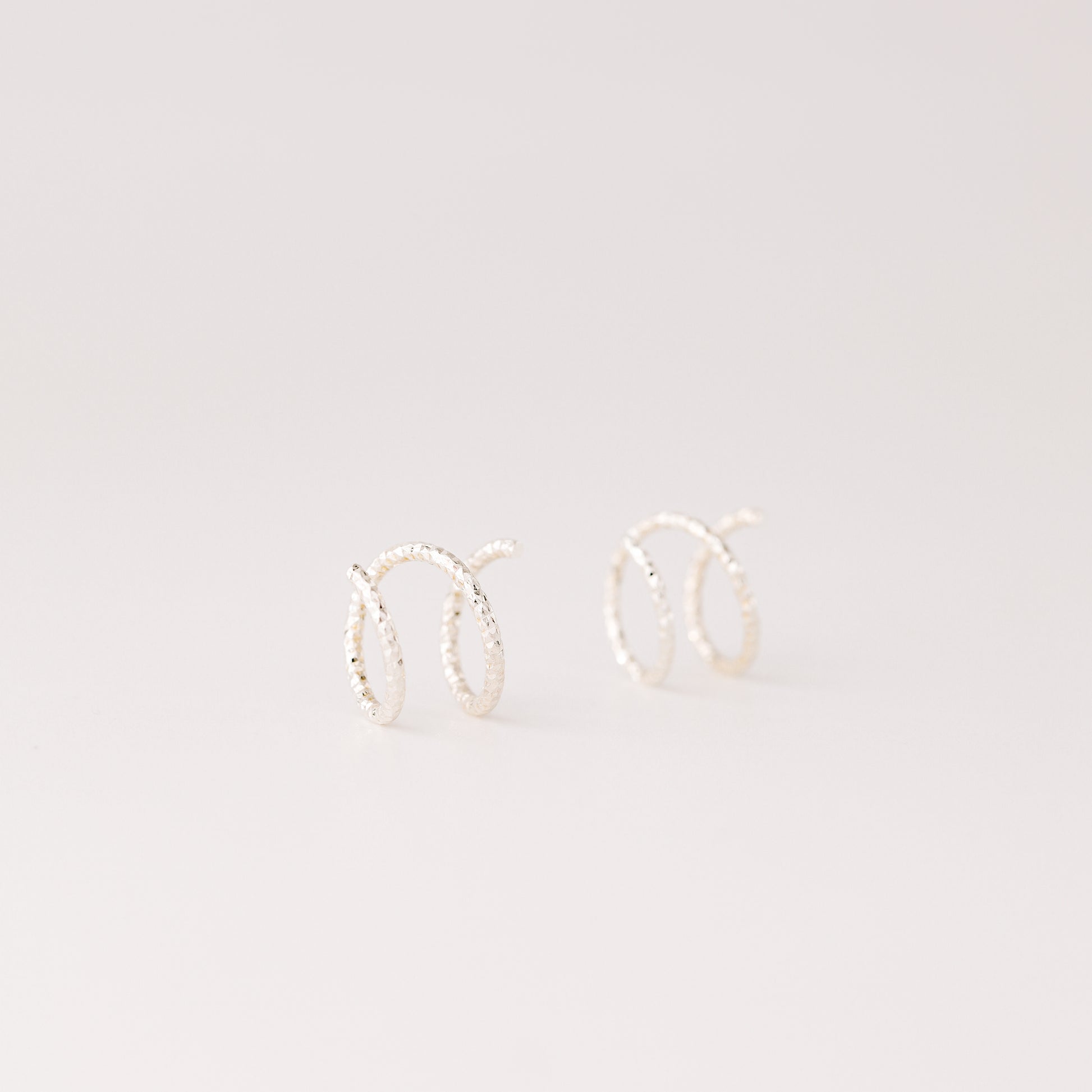 Minimal silver double hoop earrings on ear, tiny spiral earrings, sterling silver illusion double piercing jewelry